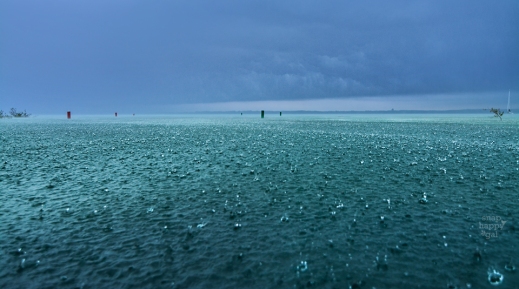 Photo: Large raindrops splash in Lake Michigan's blue waters after a summer storm's arrival