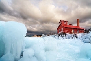 Photo: Blue ice formations below red fog signal building