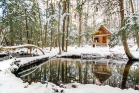 Photo: Snowy log cabin above still creek
