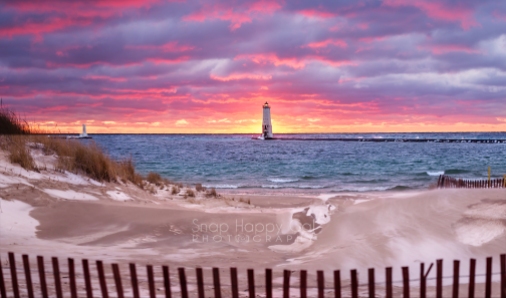 Photo: red sunset over the Frankfort lighthouse, beach and fence