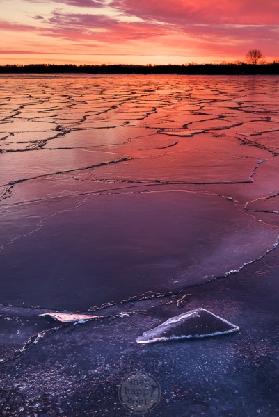 Shards of ice sit atop a cracked Lake Michigan during a red sunrise in Traverse City